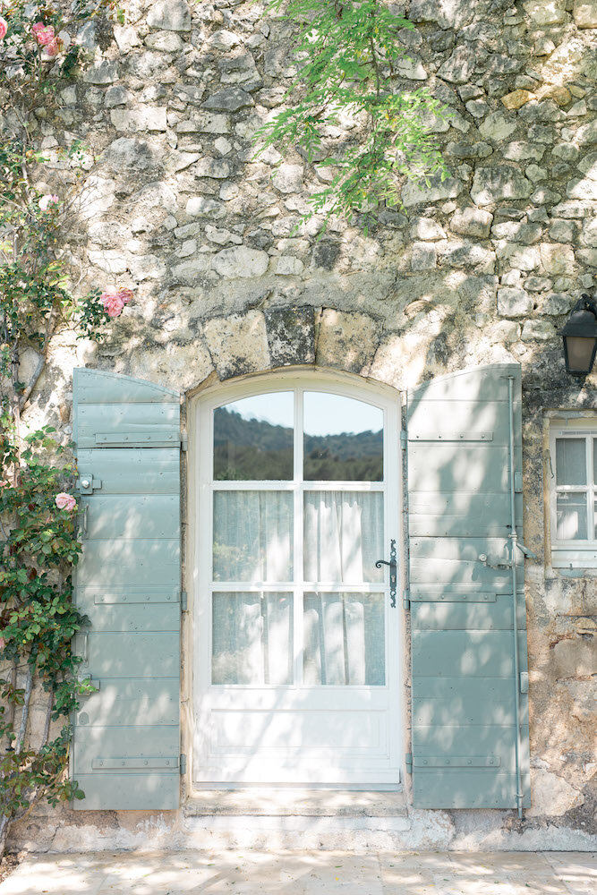 Une porte fenêtre aux volets bleus clairs typiquement provençal au domaine de la rose en provence
