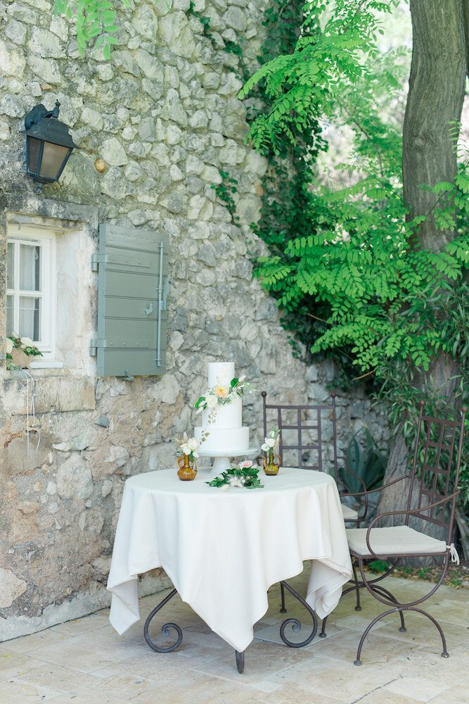 Le wedding cake mis en scène sur une petite table en fer forgé au mas de la rose.