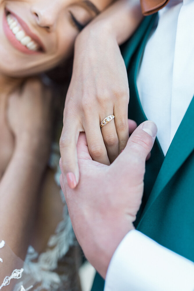Détails de l'alliance au doigt de la mariée pendant la séance couple.