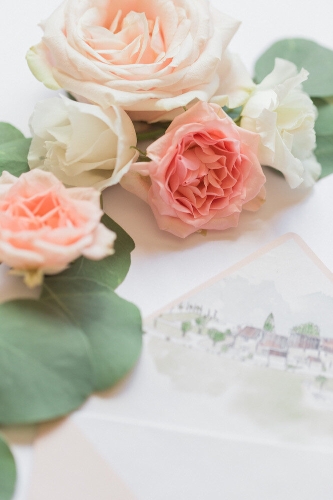 Details of the flat lay, the stationery and the pink and white roses.