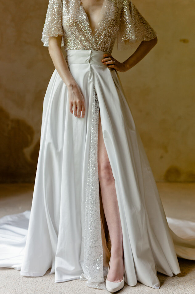 La mariée posant devant l'objectif, la jambe sortant de sa robe.