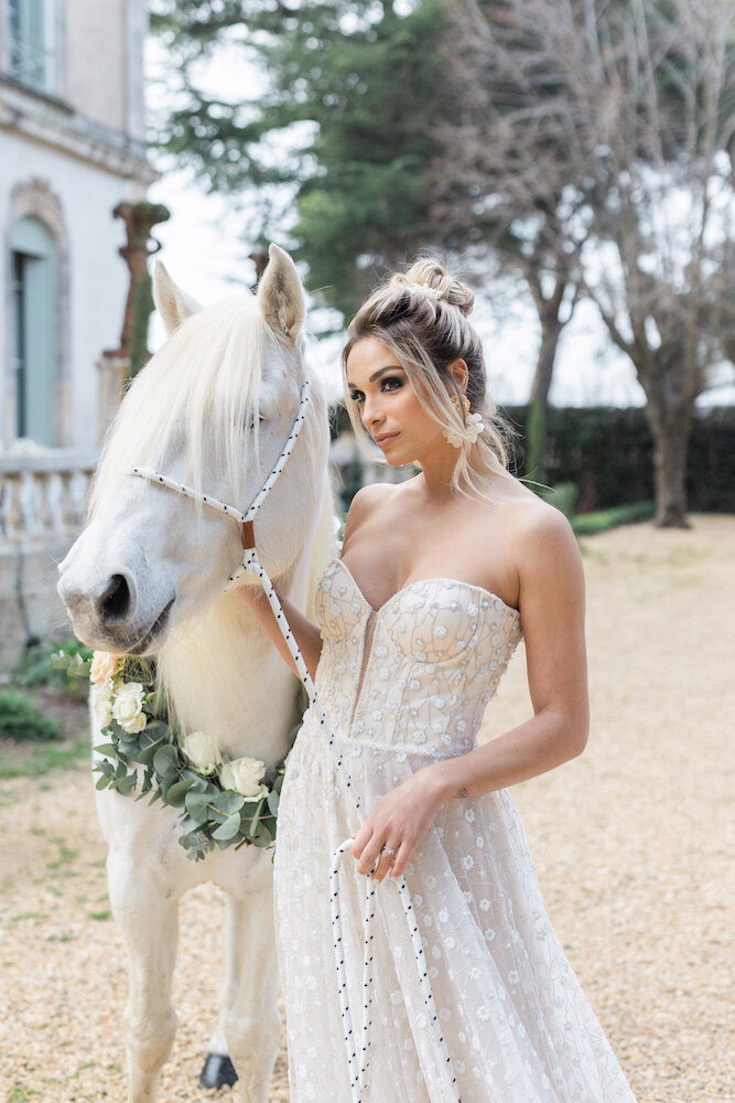 La mariée aux côté d'un cheval blanc majestueux
