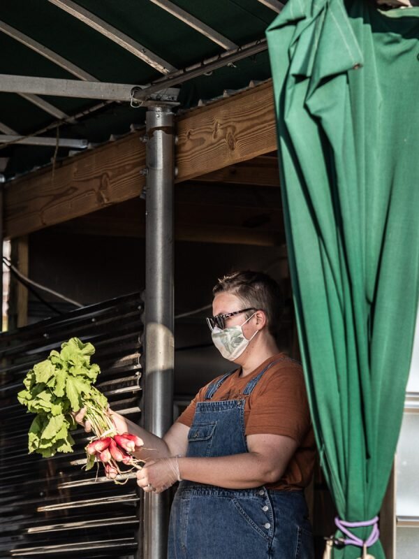 2020 June Tiffany Lopez shows off newly harvested radishes at farmstand.jpg