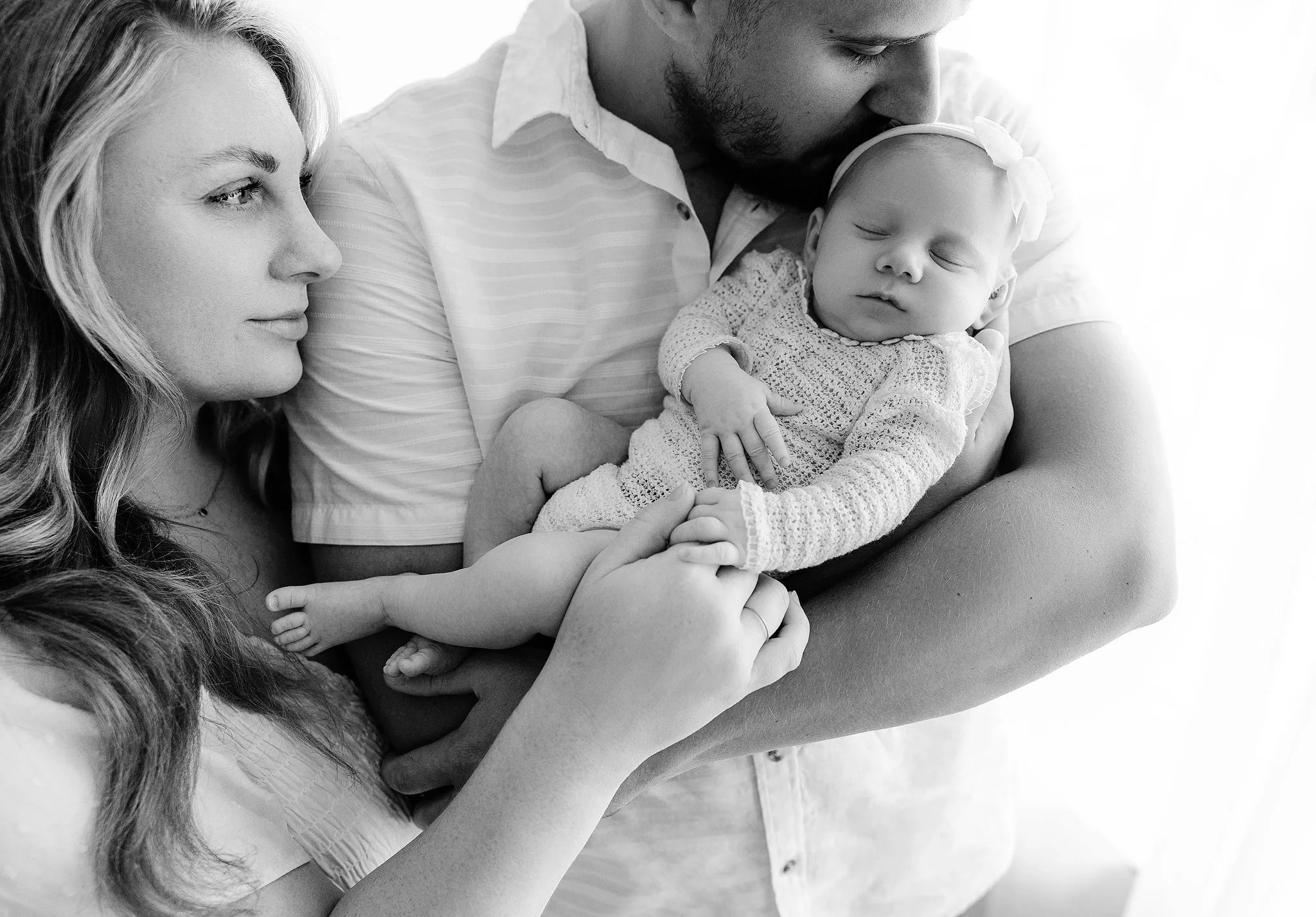 family picture of mom and dad and newborn baby girl at baby's newborn photoshoot in detroit michigan