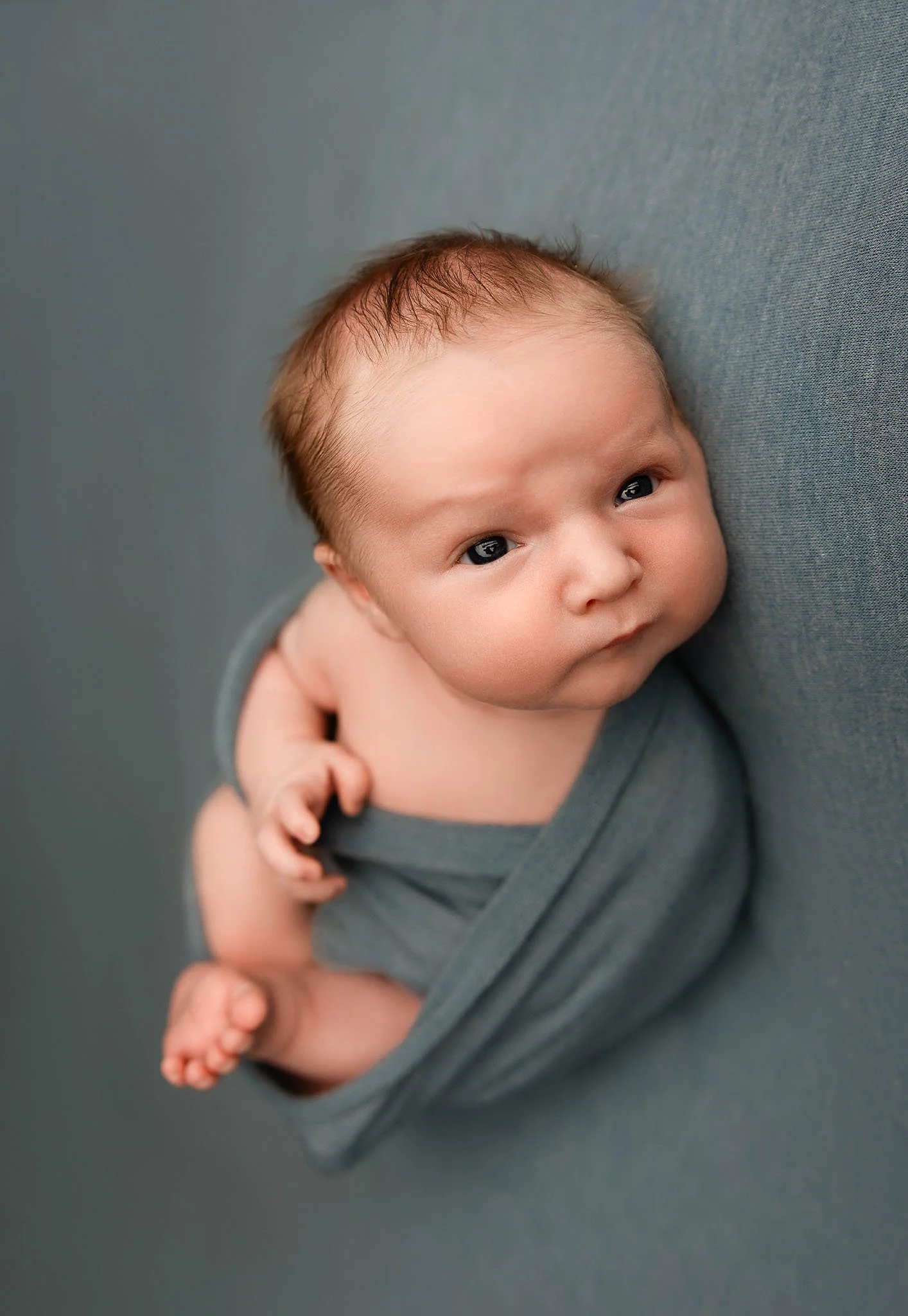 newborn baby boy swaddled and awake for newborn photosession in Utica Michigan