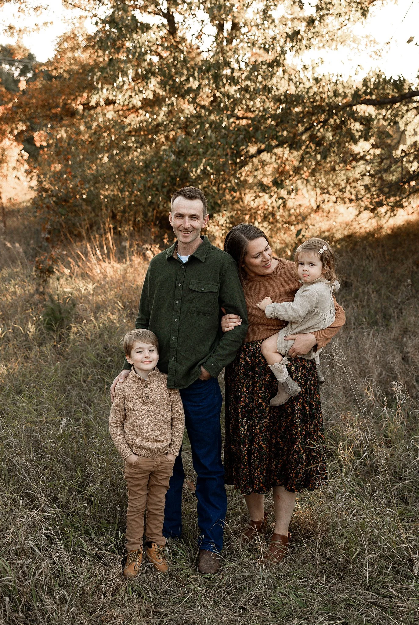 family of four at golden hour in the fall posing for family pictures