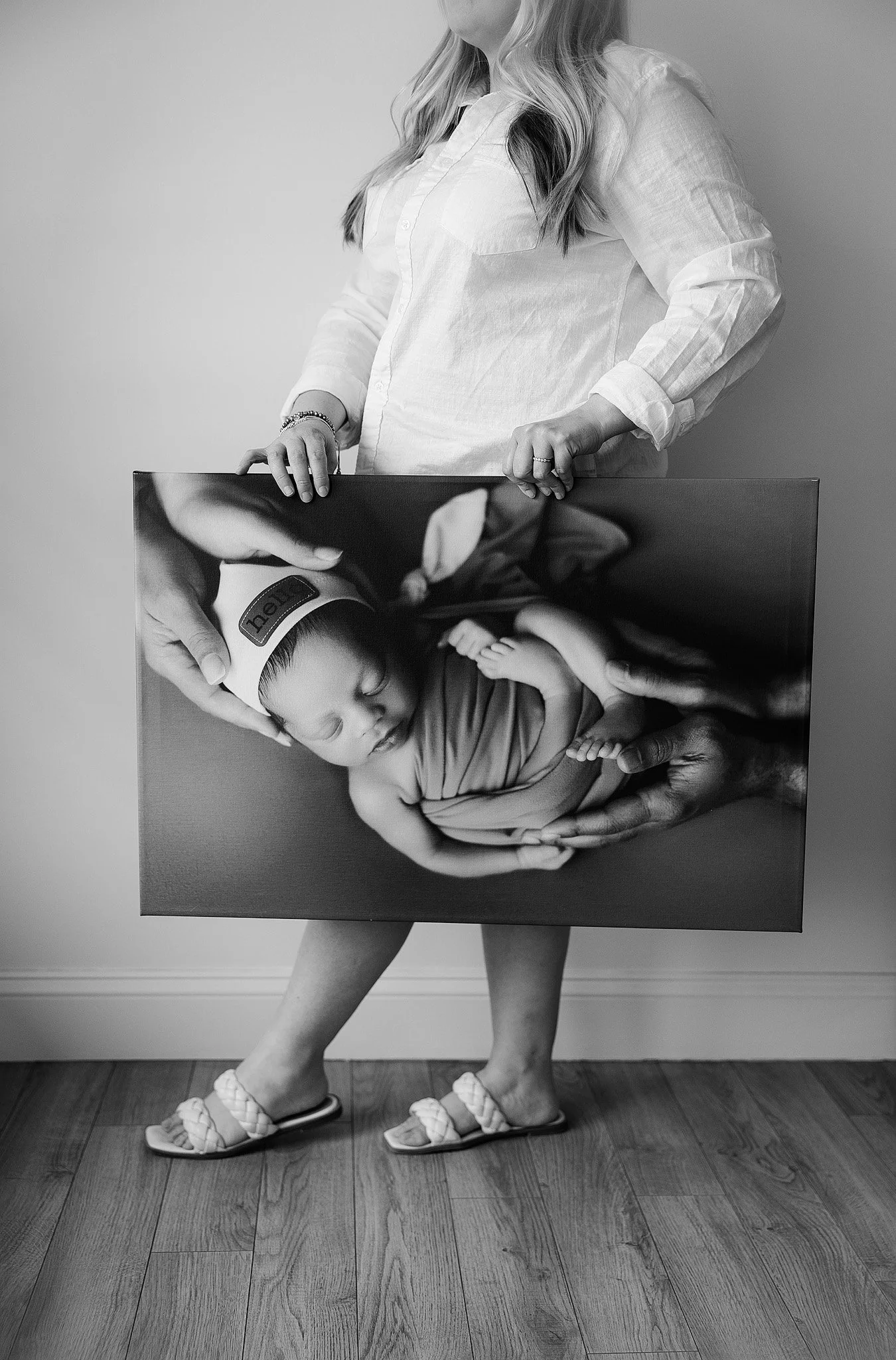 professional photographer chelsie maurer holding a large newborn baby portrait