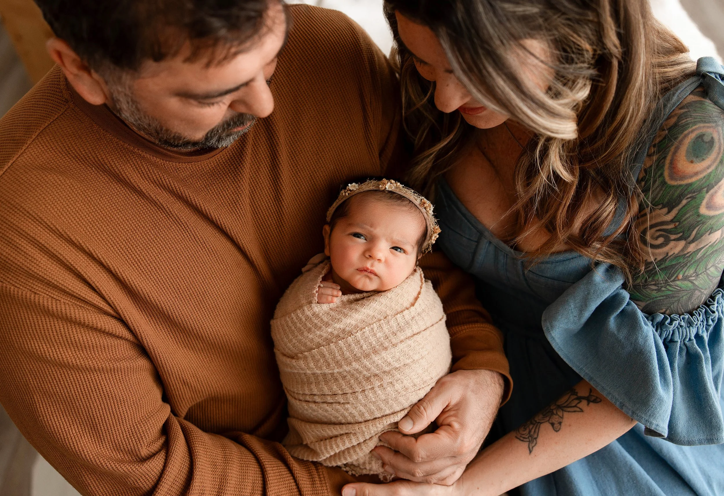 parents cuddling their newborn baby together during a studio newborn photography session