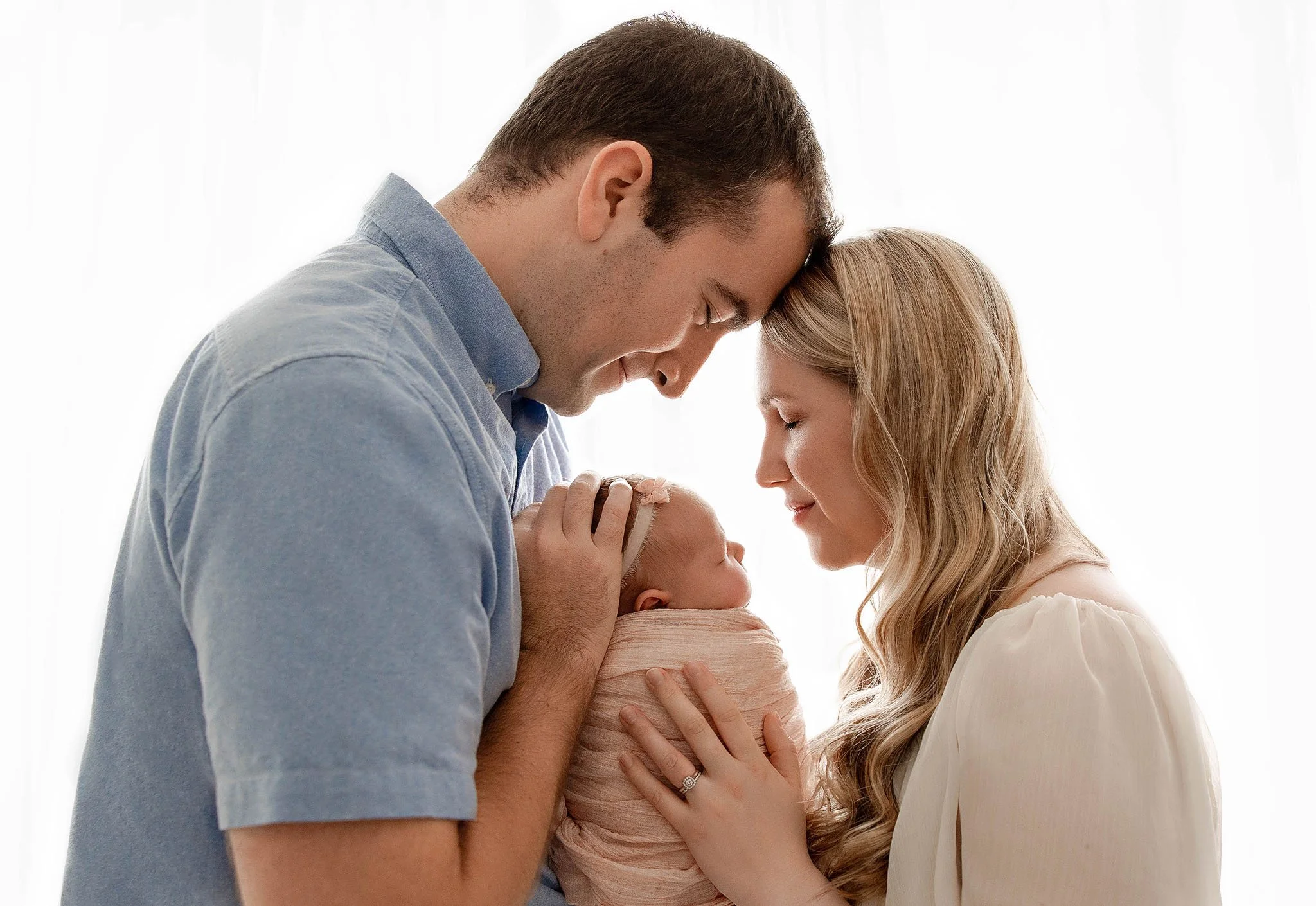 Parents holding their newborn baby during Detroit newborn photography session