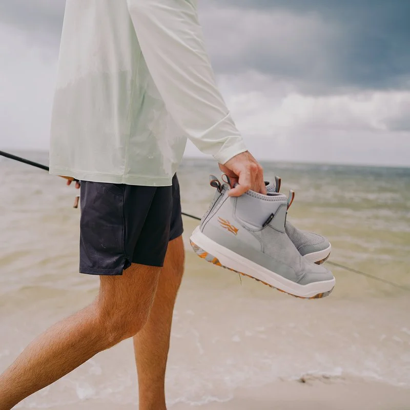 A person holding a pair of sneakers