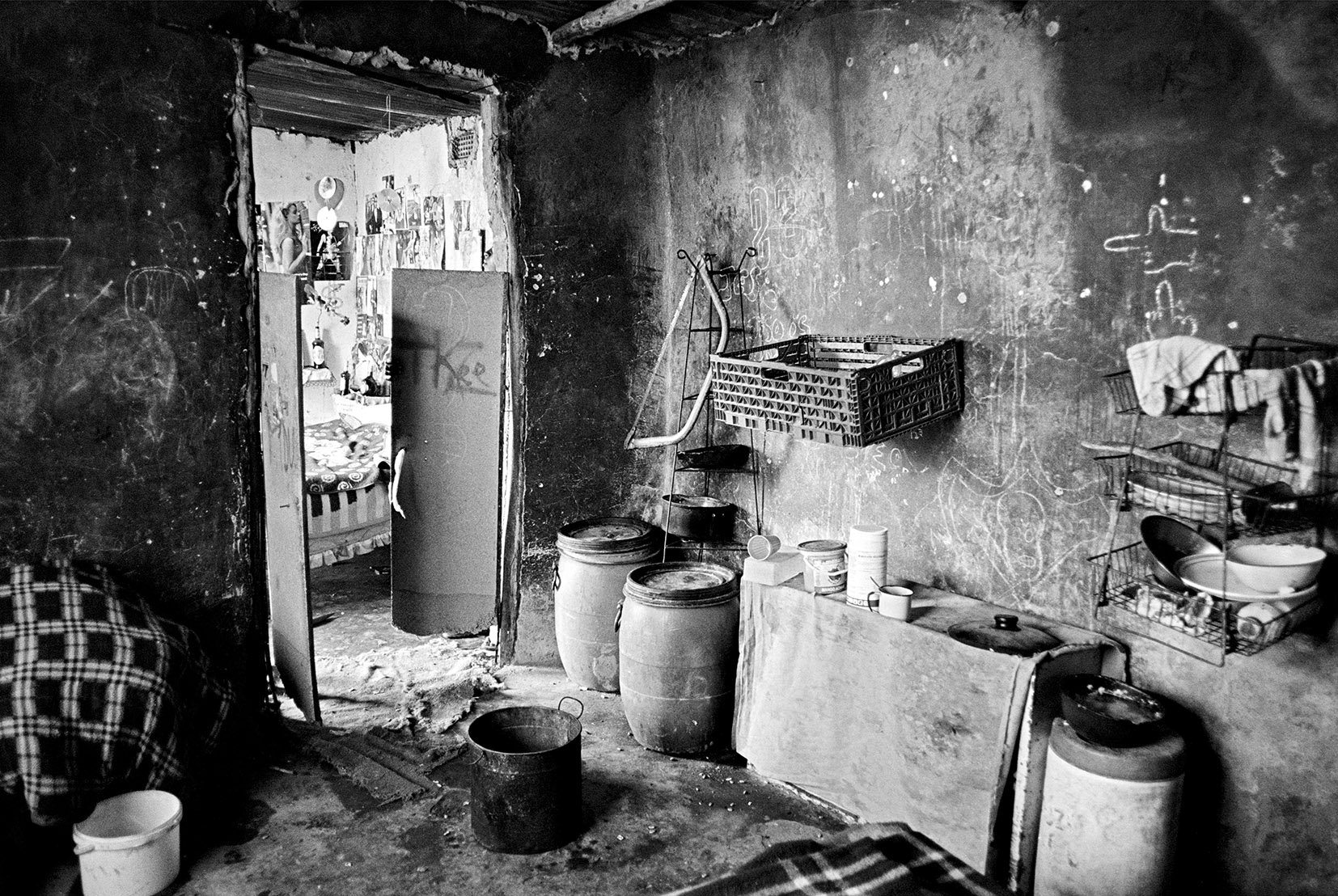  The Mkansi household photographed from the kitchen looking towards the bedroom. In the absence of their parents the three boys have graffiti-ed the walls, stuck up a large number of ‘girly’ centerfolds/ 2007 