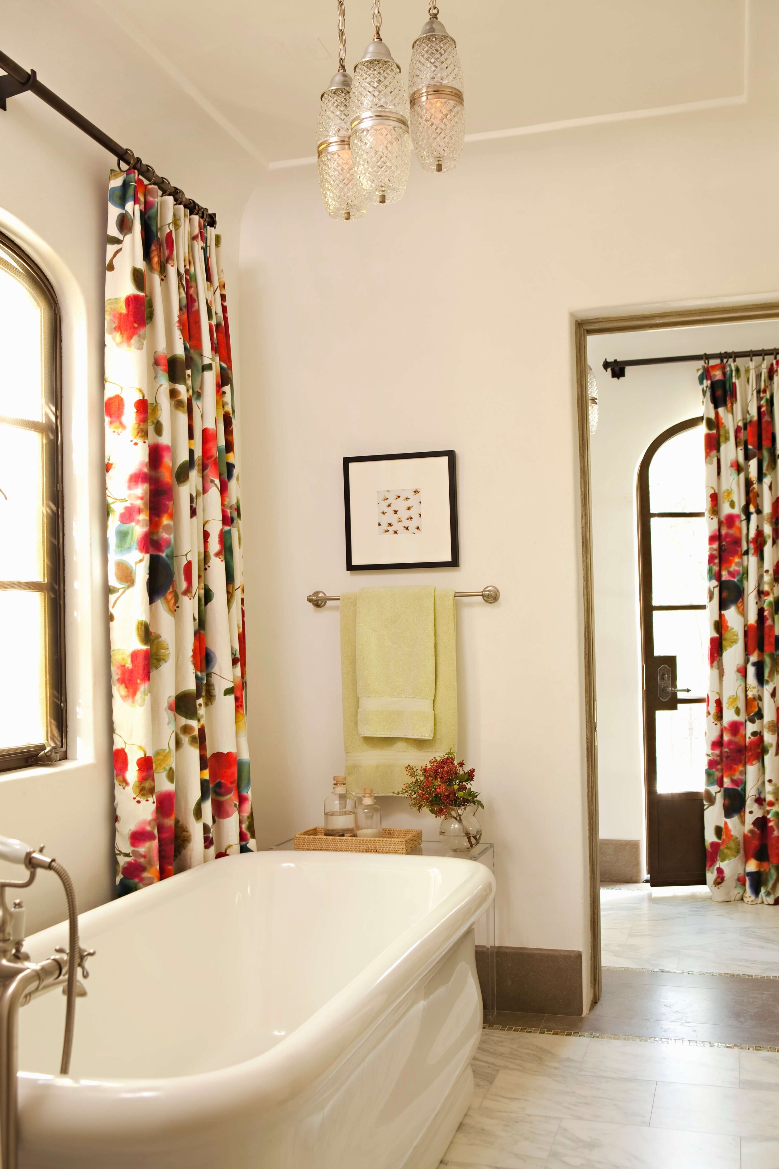 Malibu bathroom with a stand alone tube, elegant chandelier and custom floral drapery