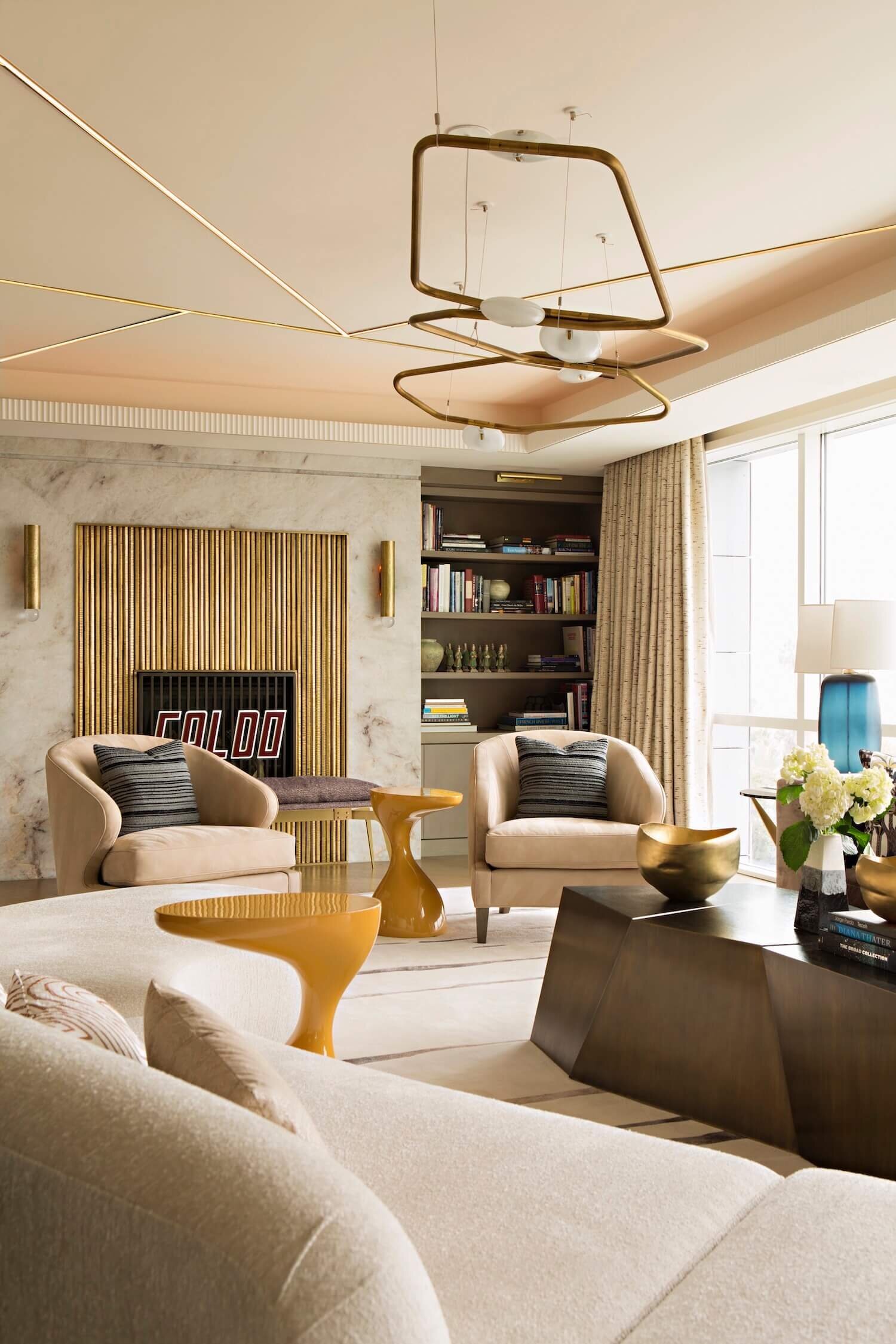 The Living Room features space area with a a hammered brass mantle, vibrant contemporary furnishing with and drapery.