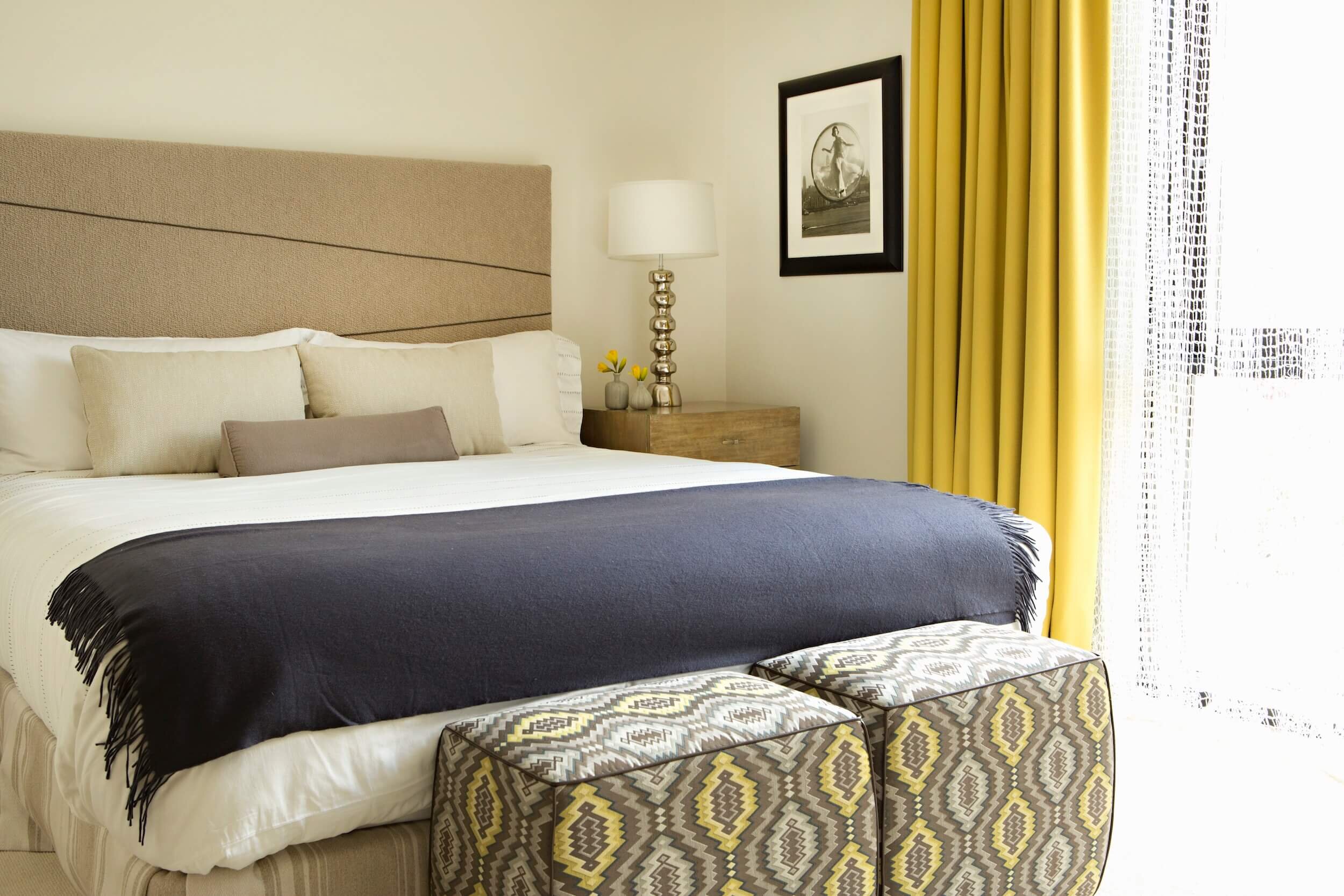 A Guest Bedroom with custom golden alpaca drapery and a bed with a handwoven cashmere headboard.