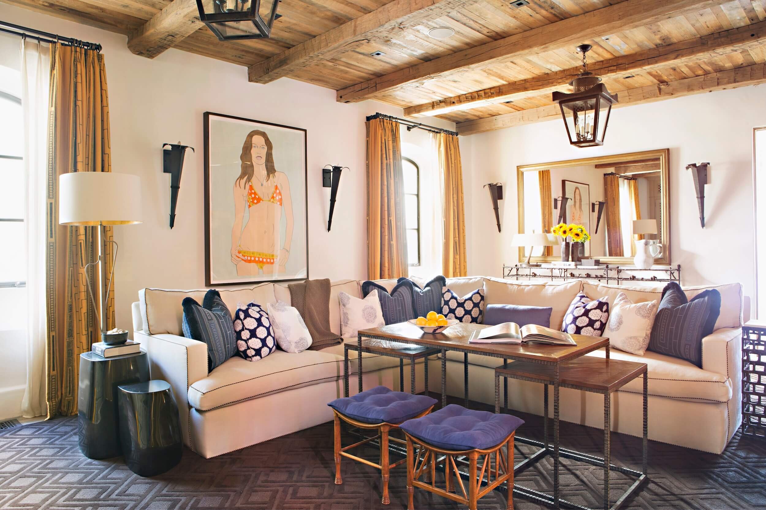 Family Room layered with reclaimed beams., amber accents with an ivory sofa and custom drapery