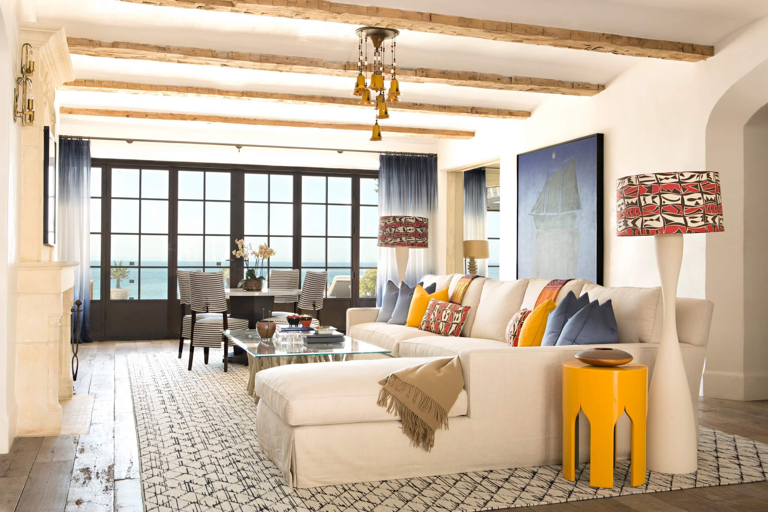 A Living room with ivory sofas and moroccan accents, stark carpeting and custom drapery