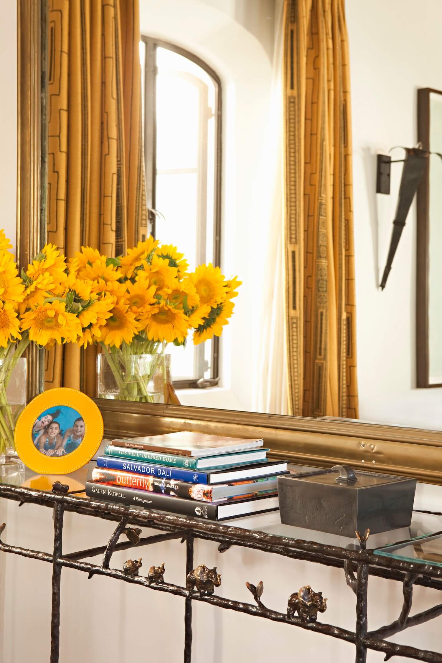 Table with Sunflowers in front of a mirror reflecting a pair of custom drapery