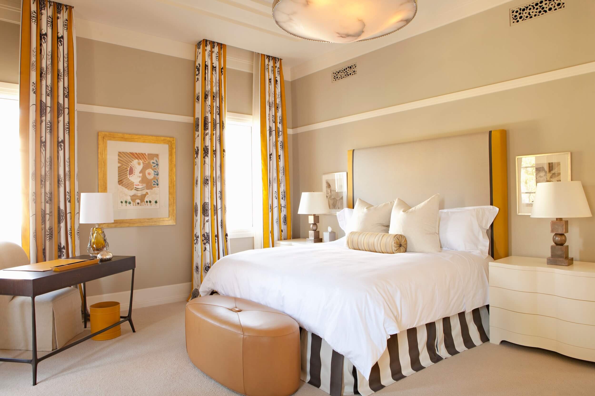 A Guest Bedroom with upholstered walls,  vibrant accents and upholstered headboard.