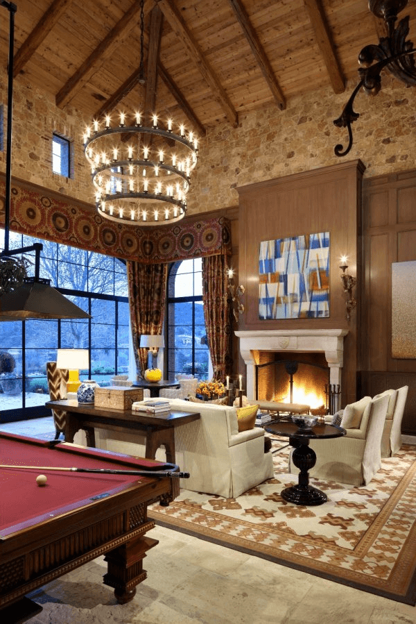 The corner of the Great Room featuring transitional furnishing, a fireplace and grand chandelier 