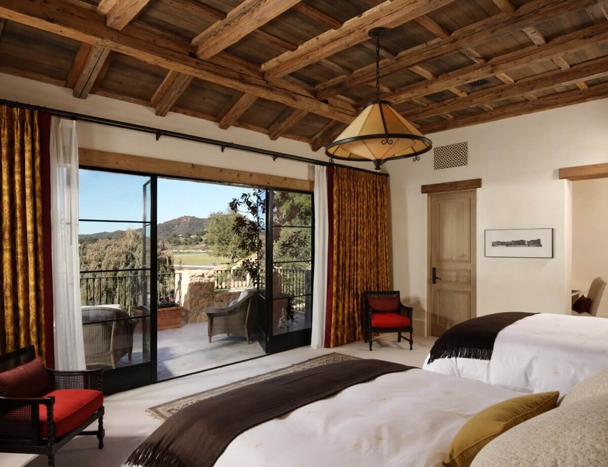 Guest bedroom with two beds,  custom drapery wood beam ceilings and view of lakebed