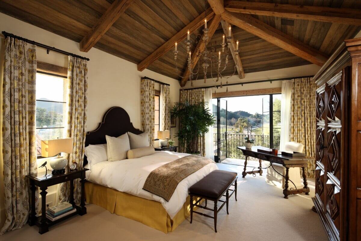 A Bedroom with a wood beam ceiling, custom drapery and view of lakebed
