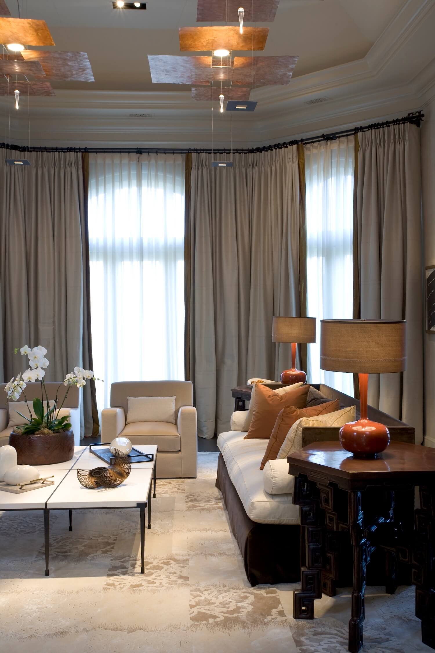 A Living room with modern sofas, contemporary tables and custom drapery