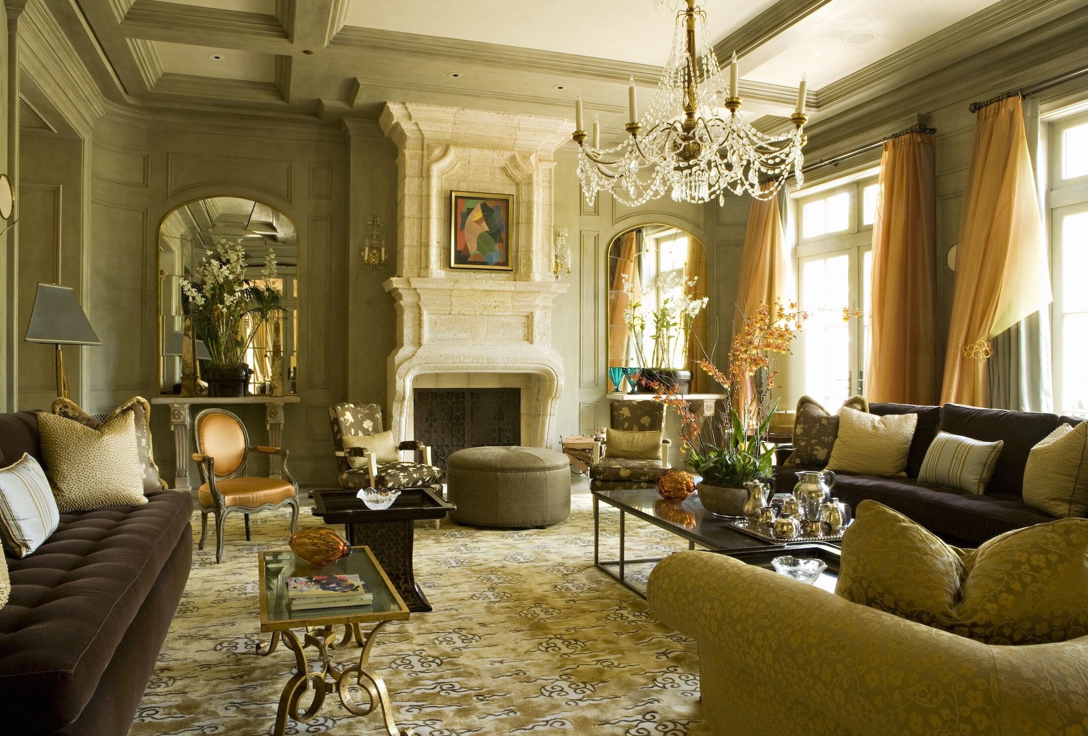A Great room filled with antique furnishing, French accents, custom drapery and large limestone fireplace