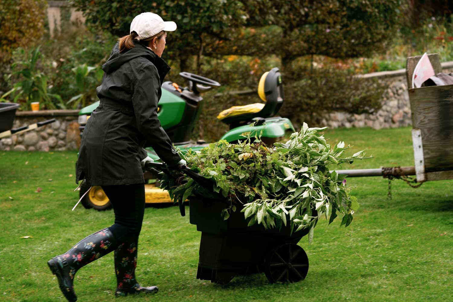  Event planning staff moving wheelbarrow of greens across manor grounds 