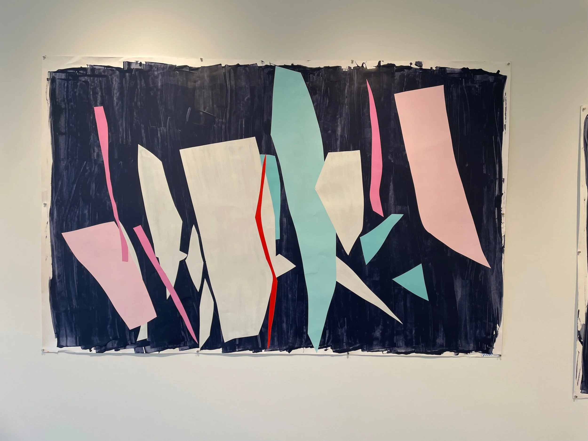 Abstract geometric artwork with irregular pastel-colored shapes on a dark background wall.