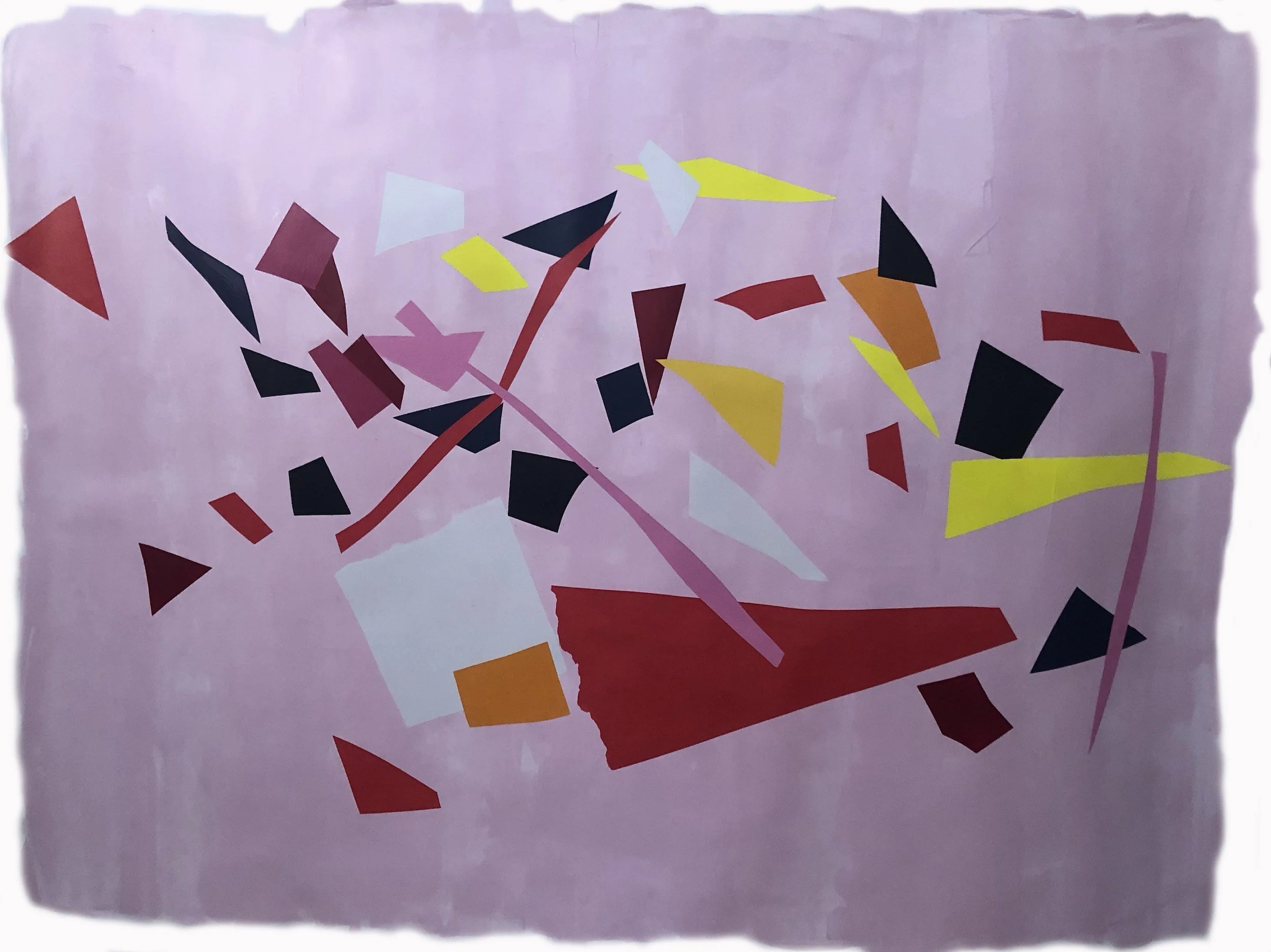 Abstract paper collage with various colored paper shapes scattered on a pink background.