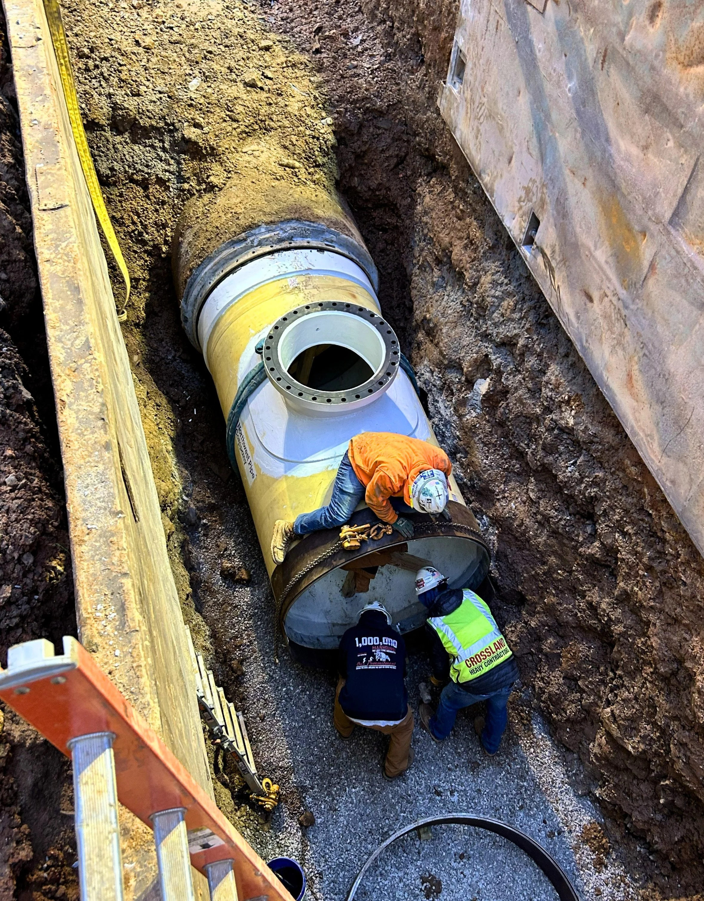 construction worker repairing a pipe, underground pipe work, JL Bryson Inc.