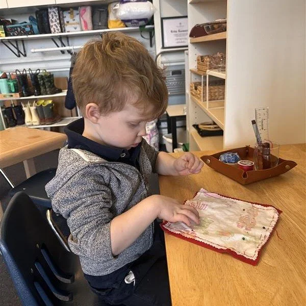 Peacefulness in the Pre-K room as students settled back in after the break. Cursive on the chalkboard, quadrilaterals, the map of Asia, sewing and button work, and building the trinomial cube. Small hands, serious work!
