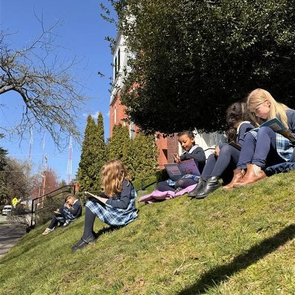 Spring sunshine means the classroom sometimes moves outside.

First grade found a quiet spot to read, while third grade practiced scenes from Julius Caesar, working through lines and staging together.

The work continues &mdash; just with a little mo