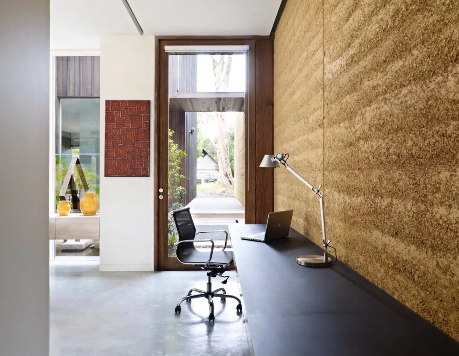 Rammed earth wall and concrete floor