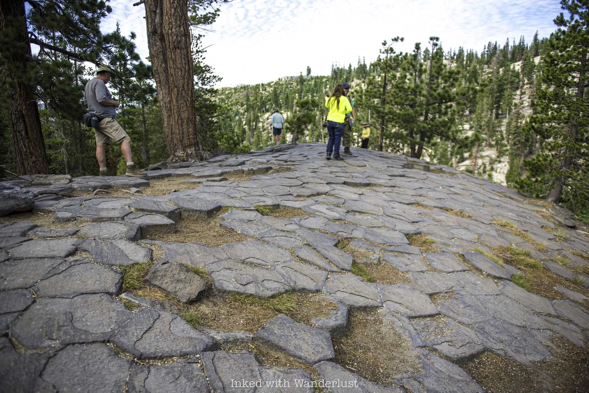 People exploring the top of Devils Postpile in California.
