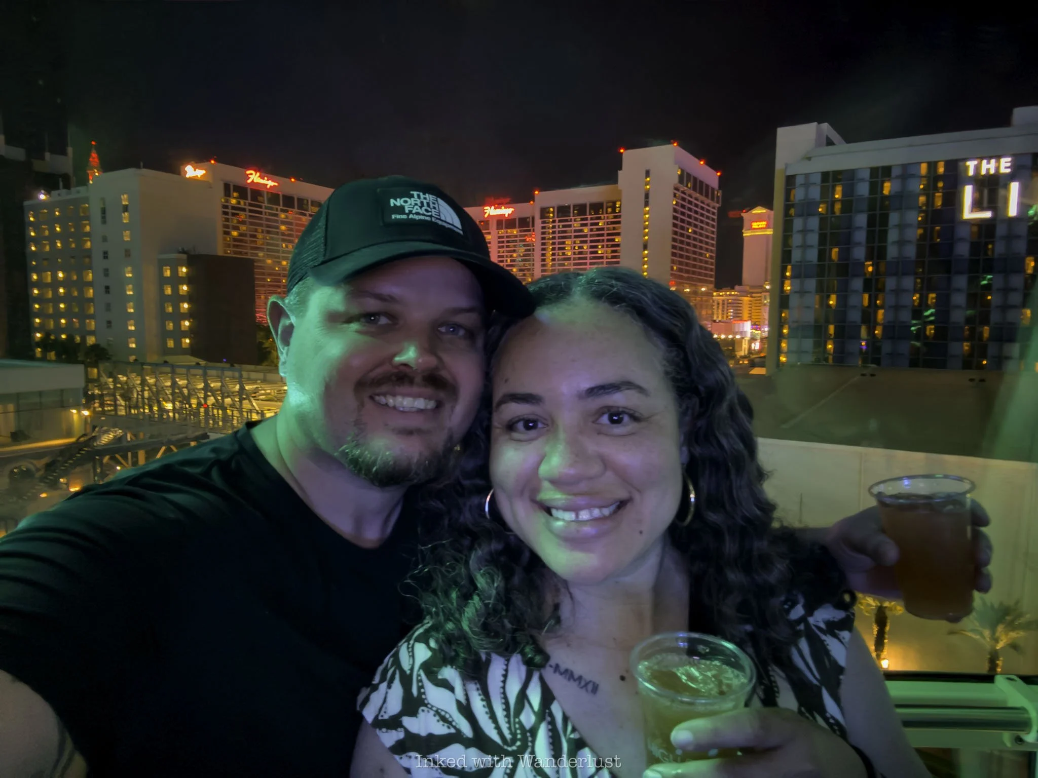 Two people on the High Roller in Las Vegas with Flamingo Hotel in the background.