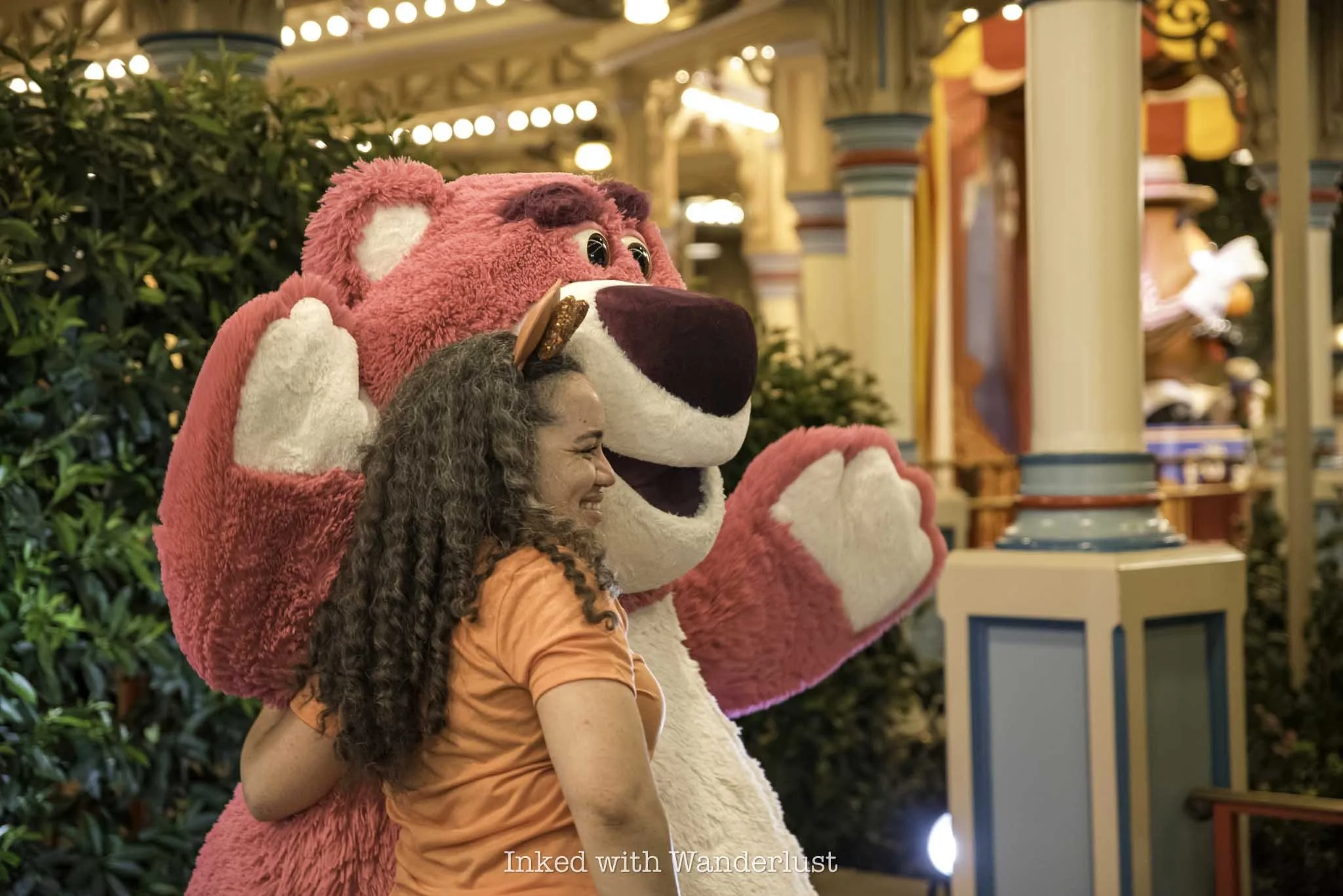 A Disney guest taking a picture with Lotso during Oogie Boogie Bash at Disneyland.