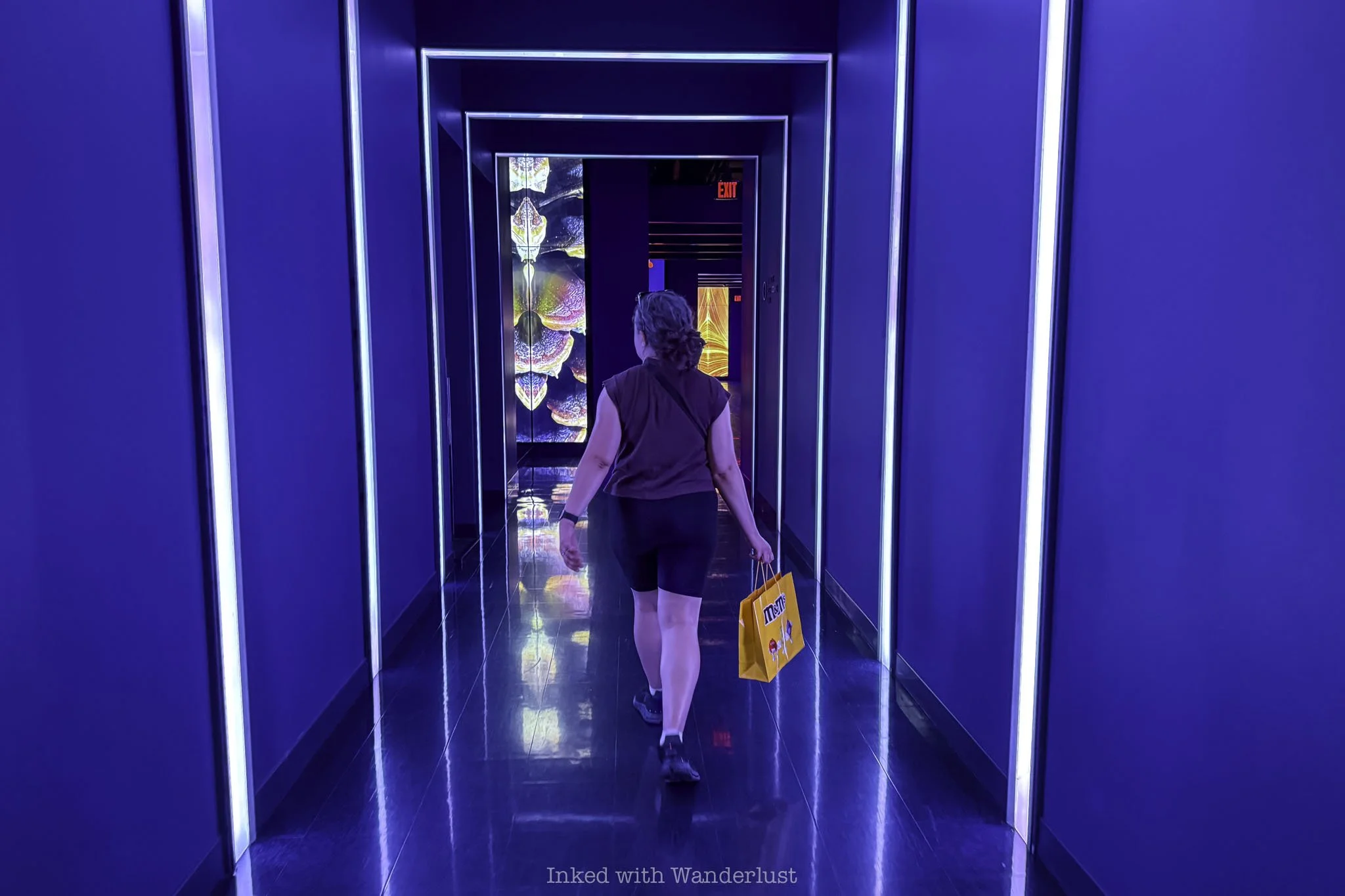 Person walking through a blue hallway at Flyover Las Vegas.