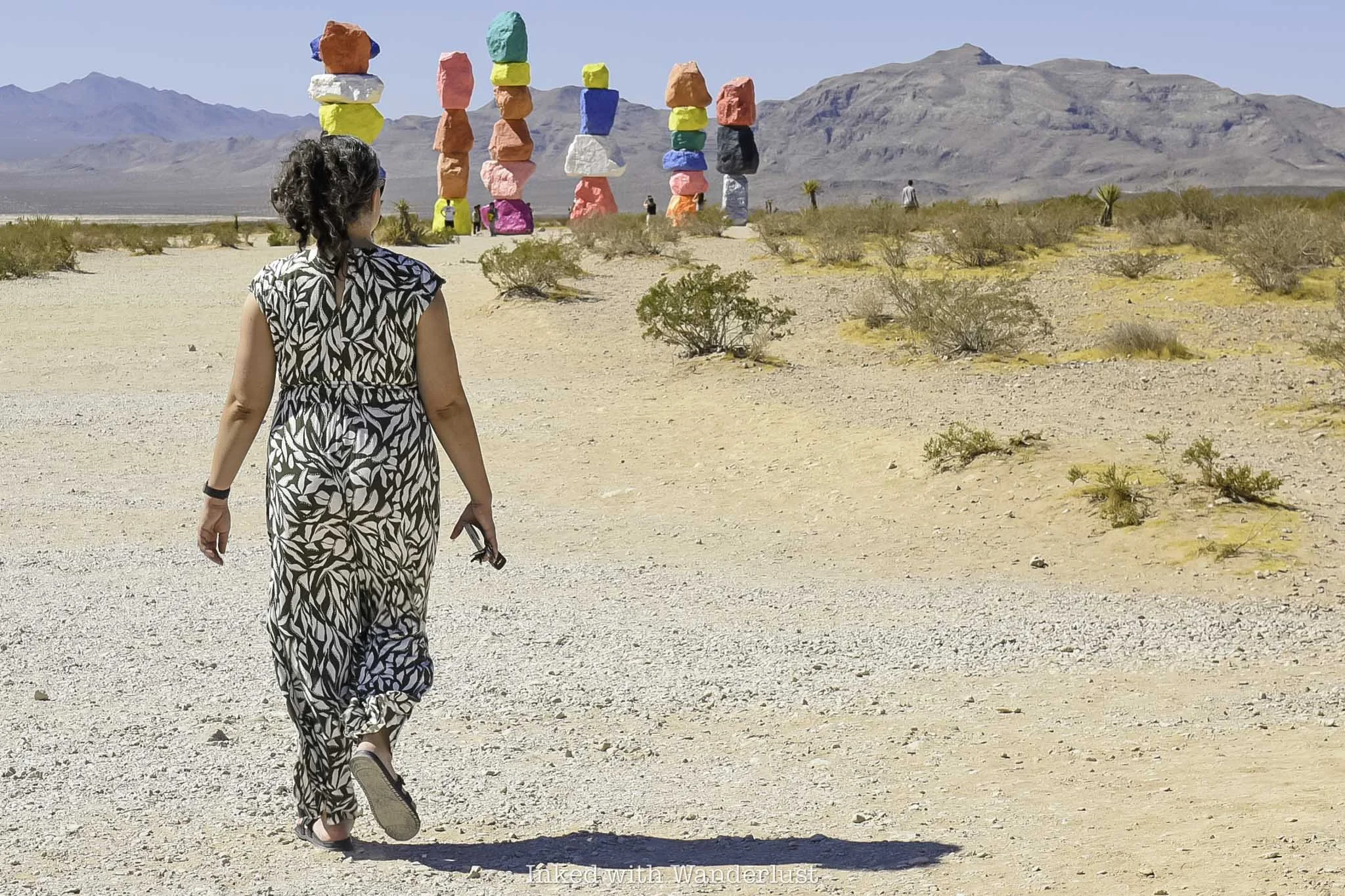 A woman walking towards Seven Magic Mountains near Las Vegas.