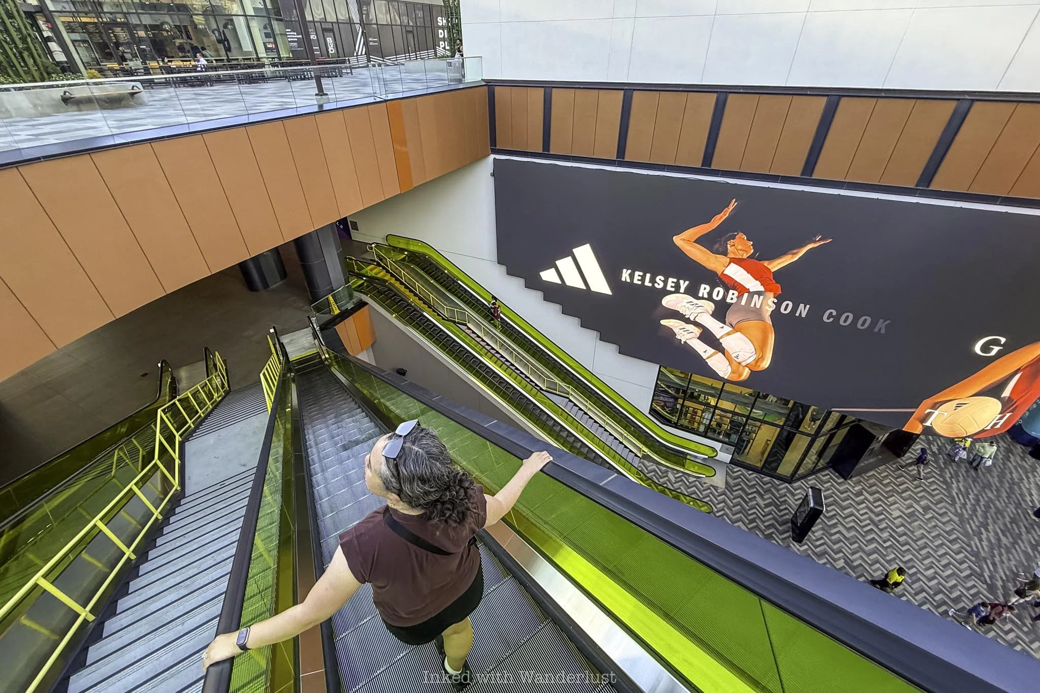 A person taking the escalator up to How Ya Dough'n Pizza in Las Vegas.