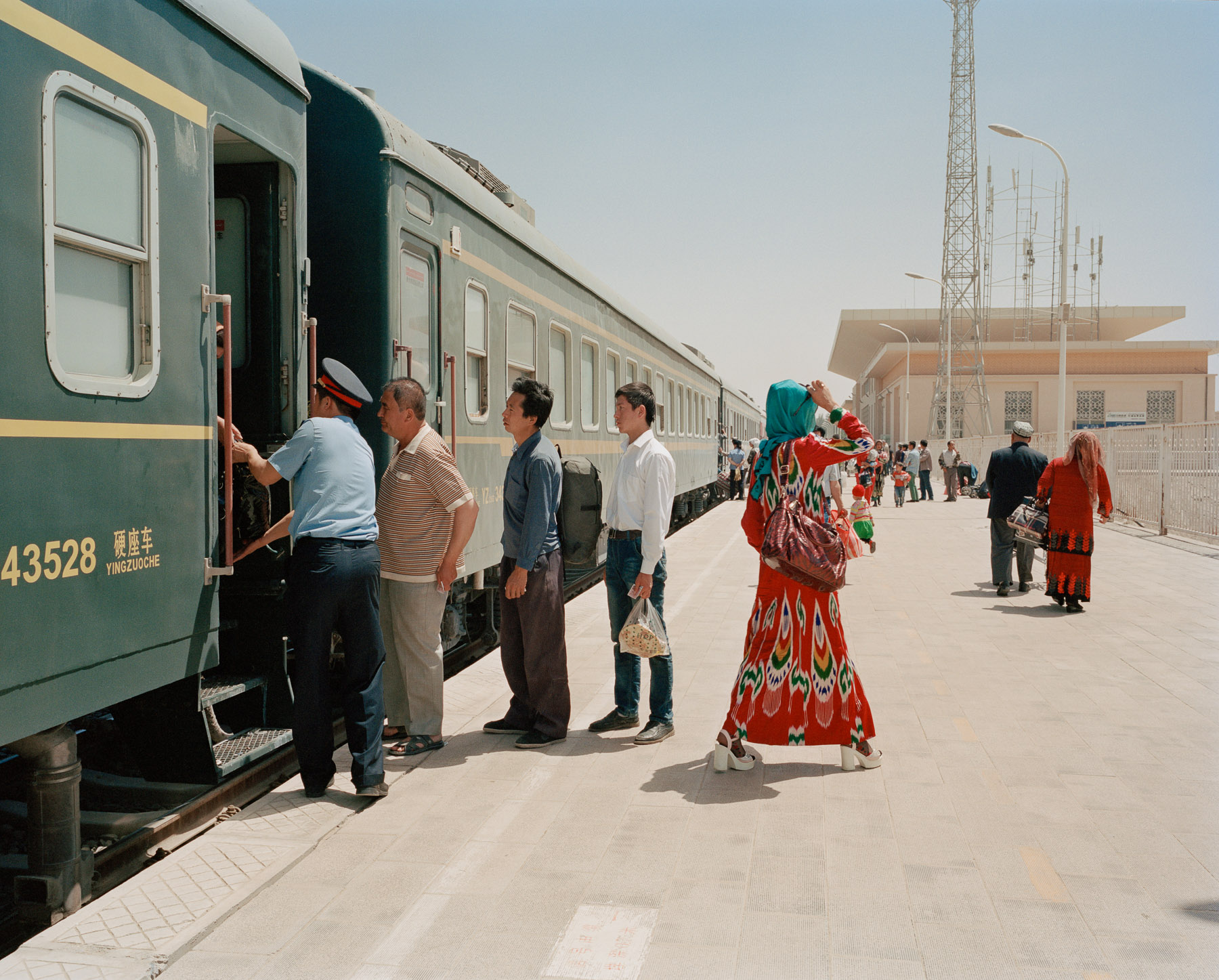  May 2016. Xinjiang province, China. Travellers getting on and off the train to Hotan at the Kashgar railway station. This is the only railway linking the oasis towns south of the Taklamakan desert where most of Xinjiang's Uighur community in Xinjian