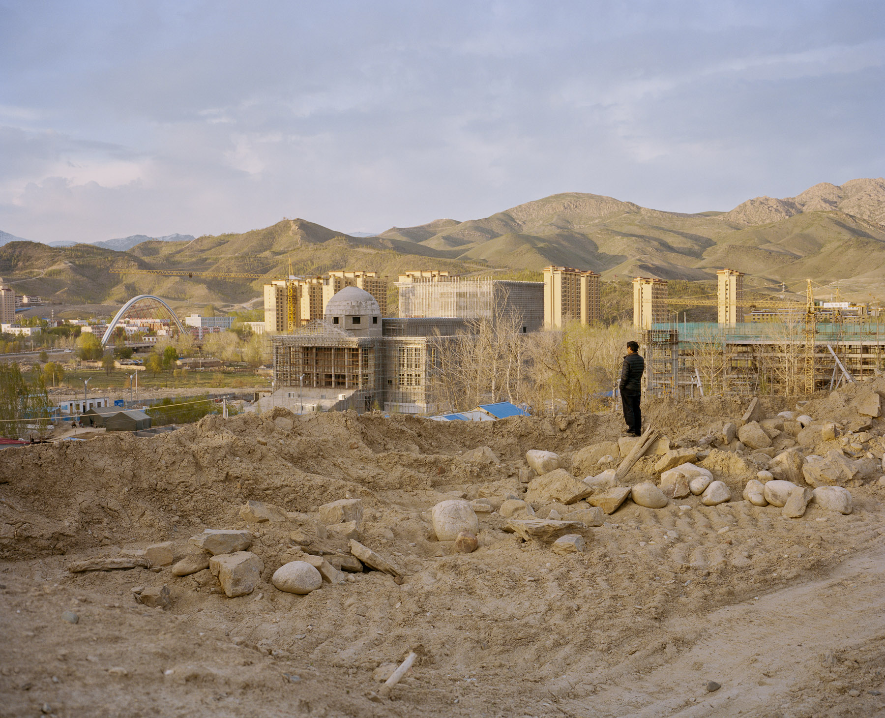  May 2017. Xinjiang province, China. Han Chinese migrant worker from the East of China making a call overlooking new constructions in Altay, a county-level city in Ili Kazakh Autonomous Prefecture, in far northern Xinjiang, China. It is the administr