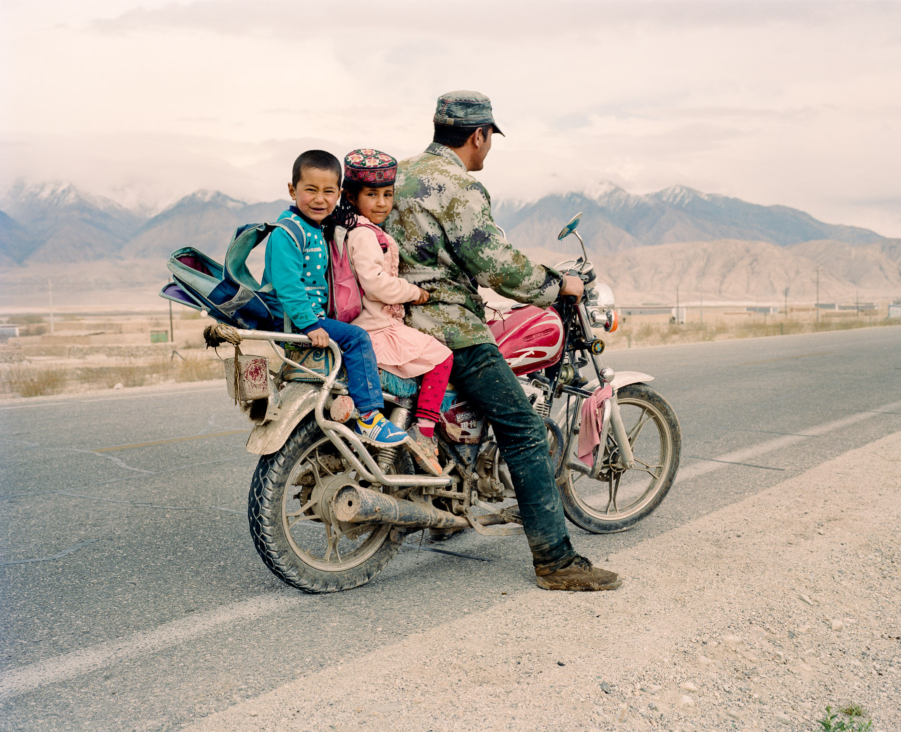 May 2016. Xinjiang province, China. Tajik father and children on the departure on the Karakoram highway that connects the Western Chinese province of Xinjiang with Pakistan and for quite a stretch runs along the Tajik border.  