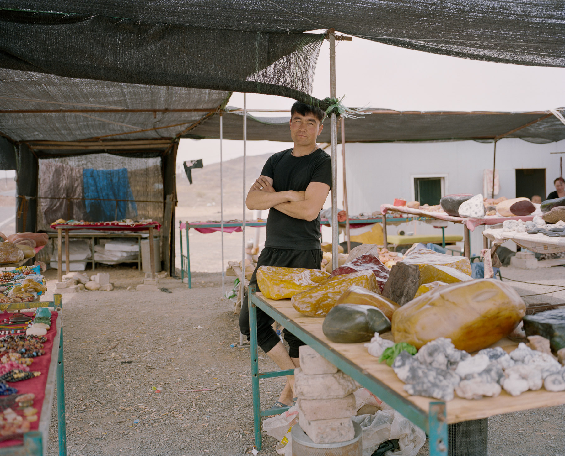  May 2016. Xinjiang province, China. Young Kazakh minority man selling stones on the side of the road in Northern Xinjiang.  