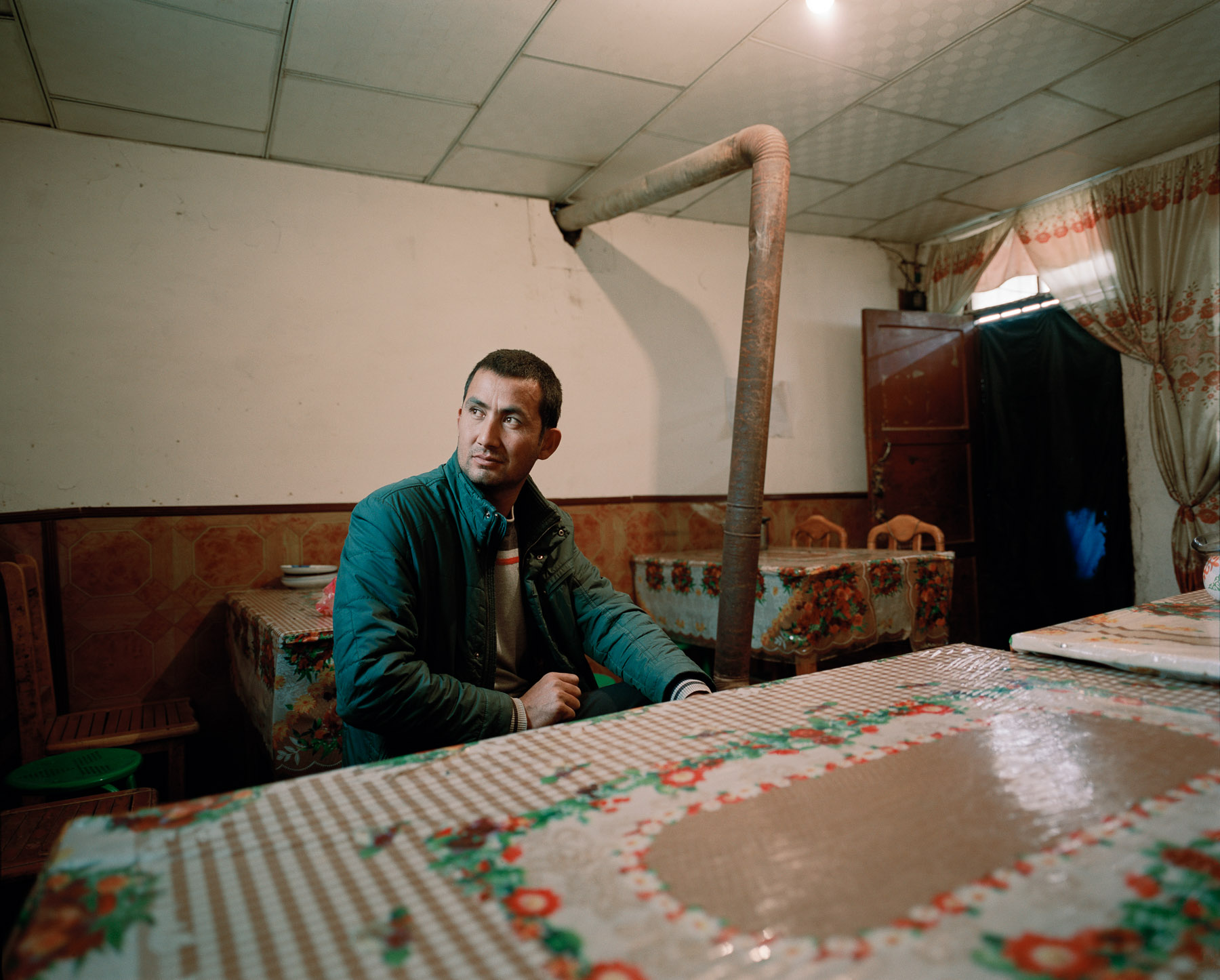  December 2016. Xinjiang province, China. Uighur man posing after his lunch in a roadside restaurant in Xinjiang.  