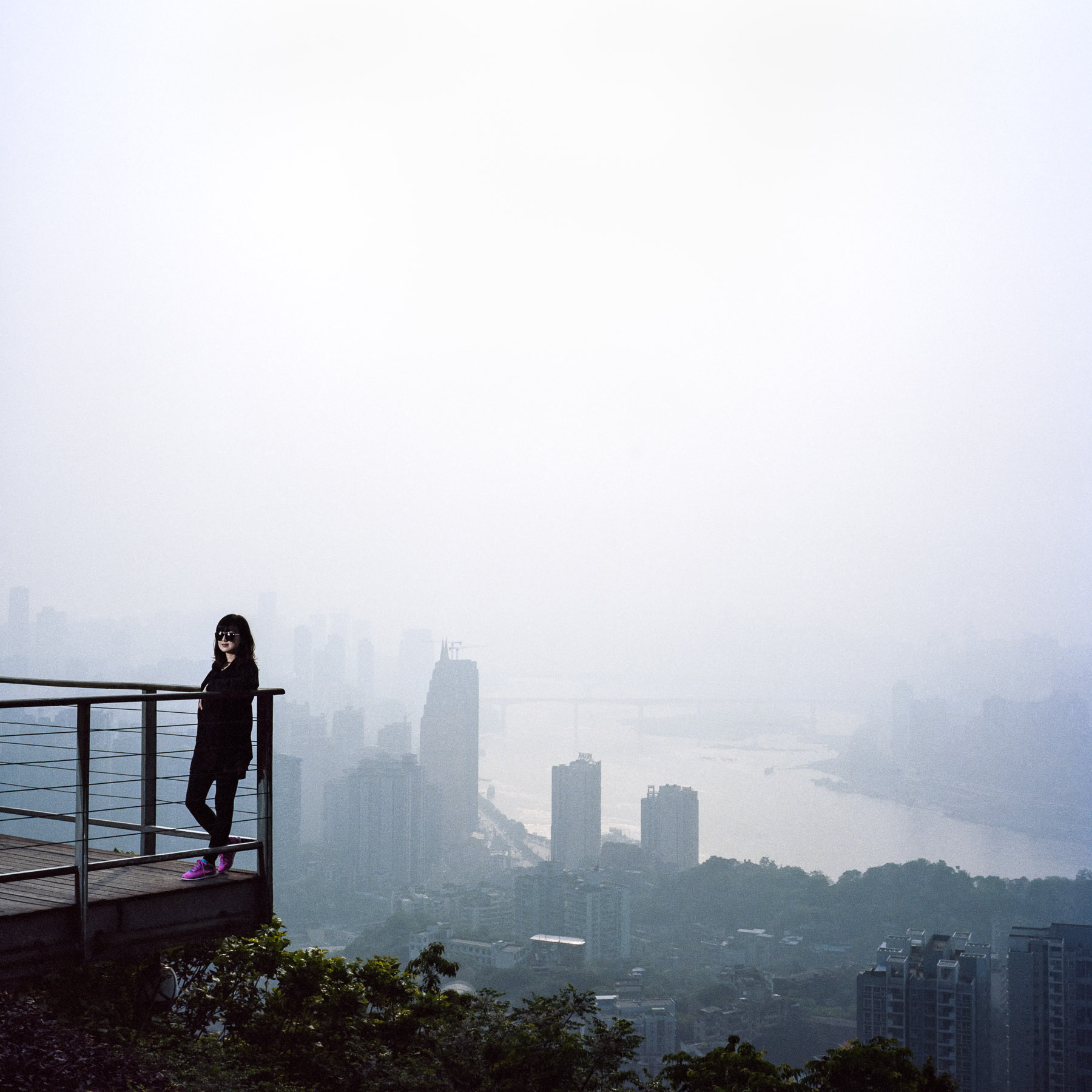  Chongqing, China. 2013. Portrait of a Chinese girl with a view of the downtown area of Chongqing's cityscape, the central Peninsula (Yu Zhong Ban Dao), over the Yangtze river from the Nanshan mountain.
Chongqing is a major city in the Southwest of C