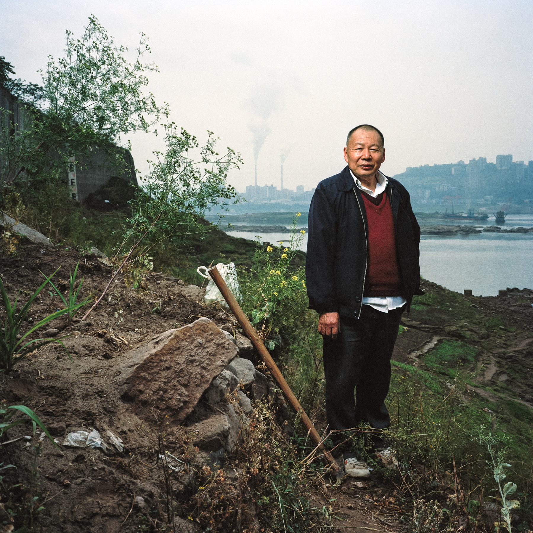  Chongqing, China. 2013. Retired chinese man posing on his small piece of cultivated land under a bridge near the Jialing river in downtown Chongqing.
Chongqing is a major city in the Southwest of China and one of the five national central cities in 