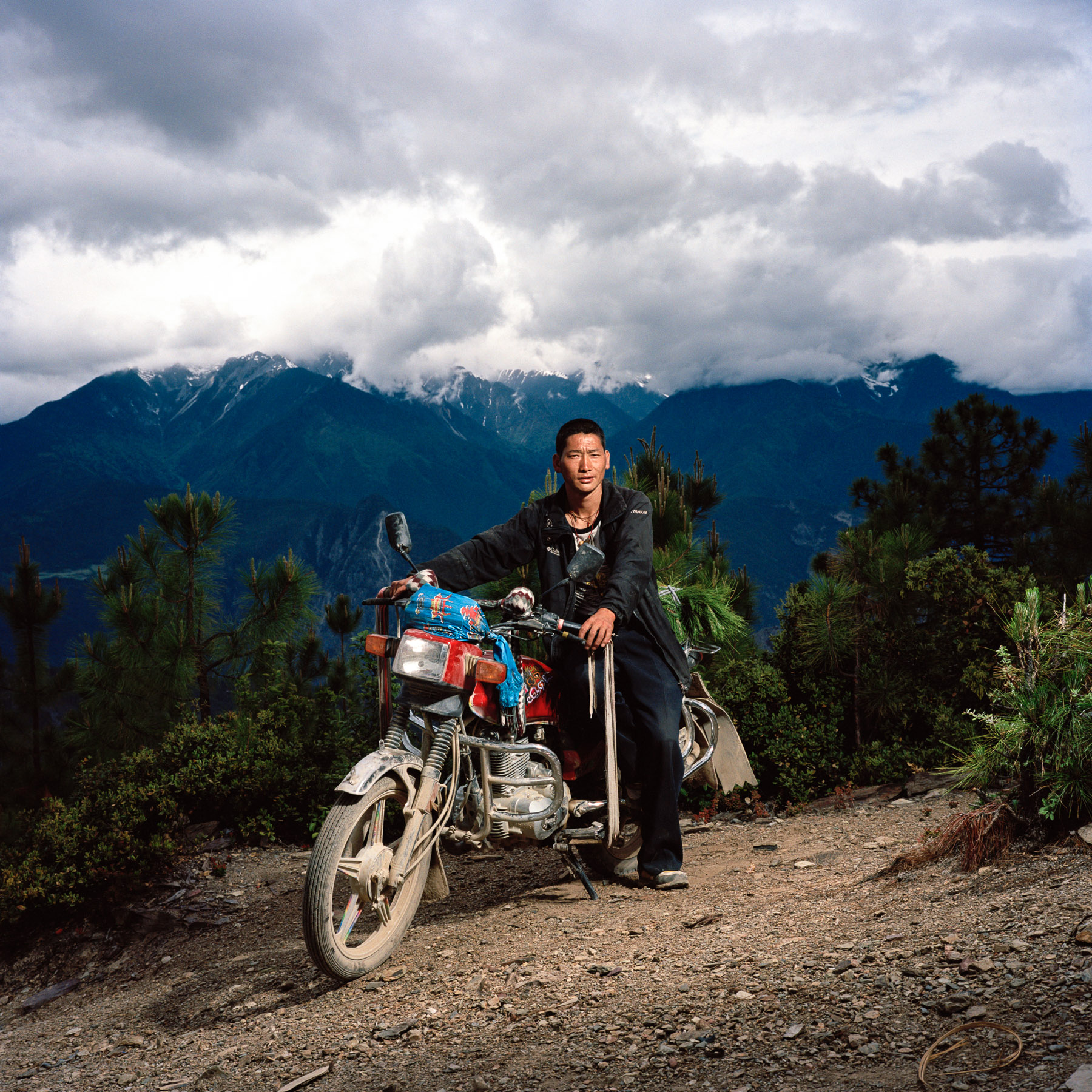  May 2012. Tibet province, China. Portrait of Banu, a 35-year old Tibetan farmer on his bike riding back to his village. A few hours trekking from the village of Aben, at the border with the province of Yunnan, at 3250m high. On the trail of the budd