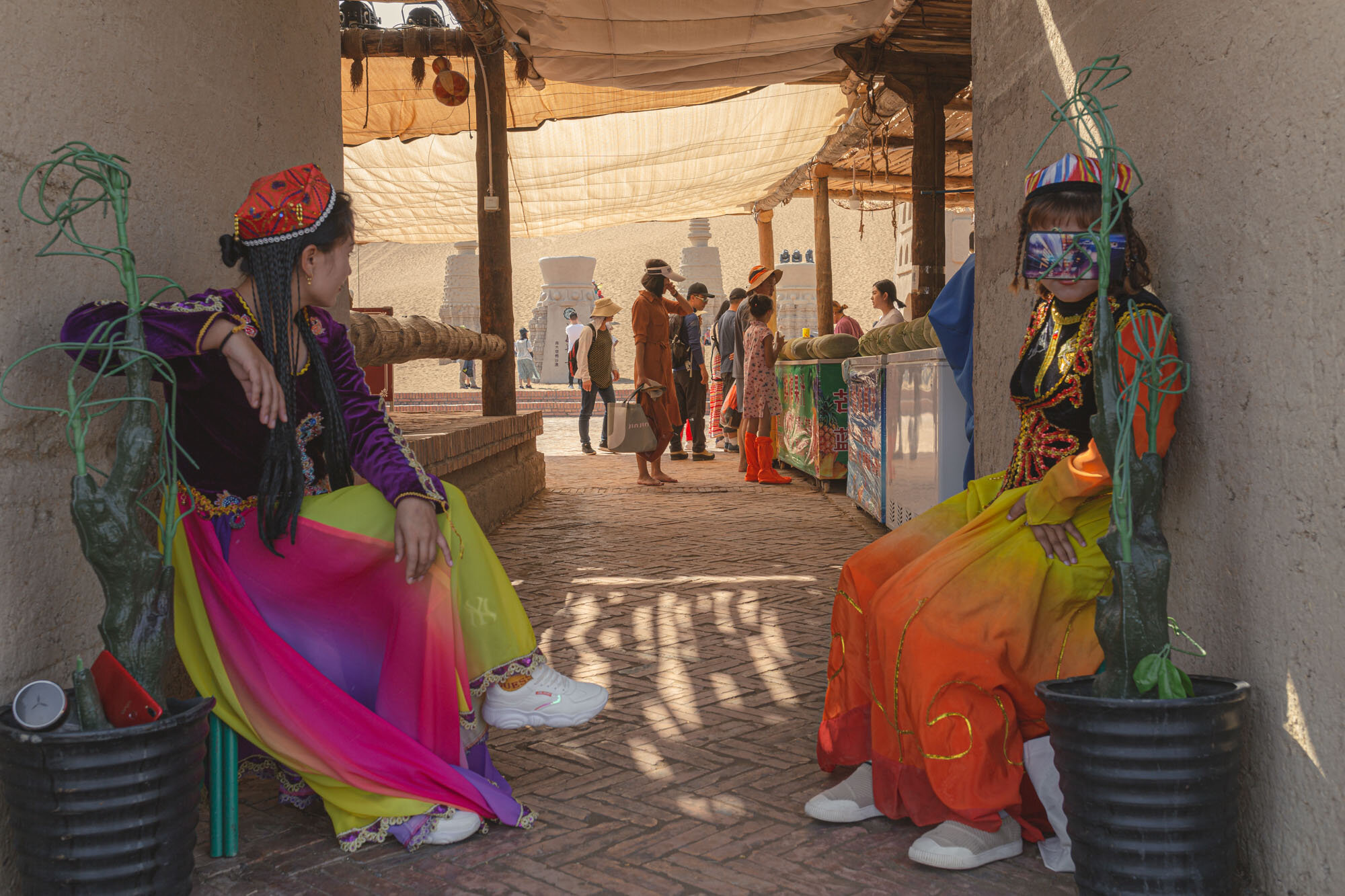  September 28th 2019. Shanshan County, Xinjiang province, China. On the site of the Kumtag Desert Scenic Area, a desert-tourism park catering mostly to Han-Chinese tourists. Young Uighur women dressed up in folklore flashy dresses offer to pose for m