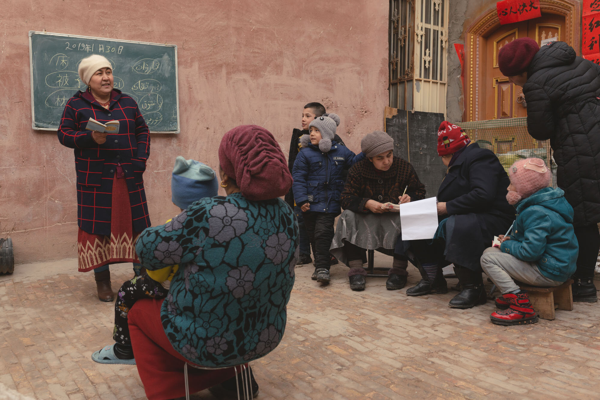  January 31st 2019. Kashgar, Xinjiang province. Uighur-minority residents - young and old - of a neighbourhood in the old town attend an outdoor Mandarin language class. 